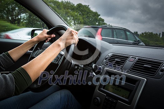 Male driver's hands driving a car on a highway (color toned image; shallow DOF) Male driver's hands driving a car on a highway (color toned image; shallow DOF)