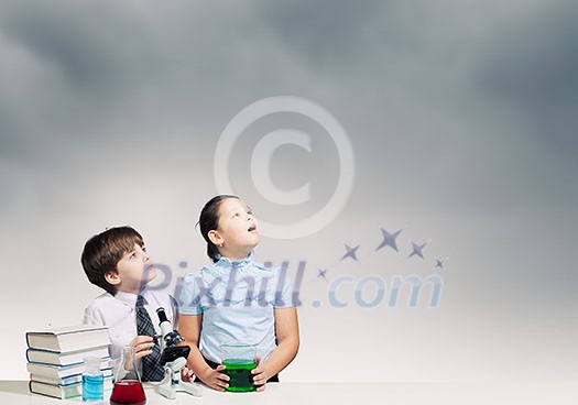 Two cute children at chemistry lesson making experiments Two cute children at chemistry lesson making experiments