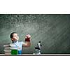 Cute school girl at chemistry lesson with test tube