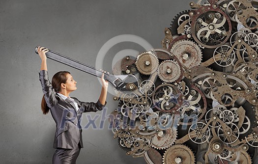 Young businesswoman fixing gears mechanism with wrench Young businesswoman fixing gears mechanism with wrench