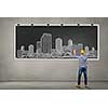 Rear view of man engineer in helmet drawing on chalkboard