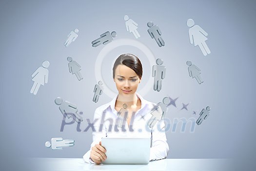 Attractive businesswoman sitting at table and using tablet
