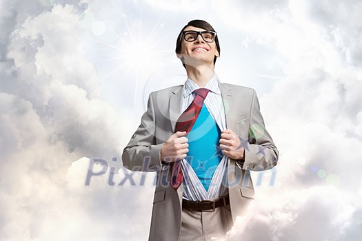 Young smiling businessman acting like super hero and tearing his shirt off Young smiling businessman acting like super hero and tearing his shirt off