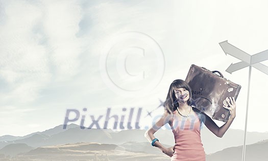 Young pretty girl with her retro suitcase on shoulder
