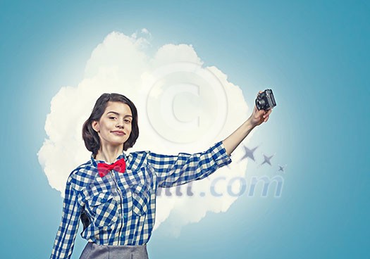 Young beautiful woman making selfie photo with retro camera