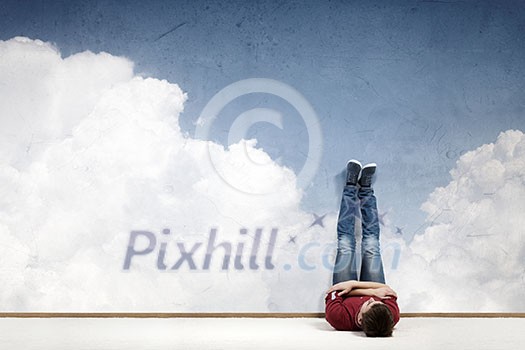 Young man lying on floor with legs raised up Young man lying on floor with legs raised up