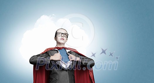 Businesswoman wearing red cape and opening her shirt like superhero
