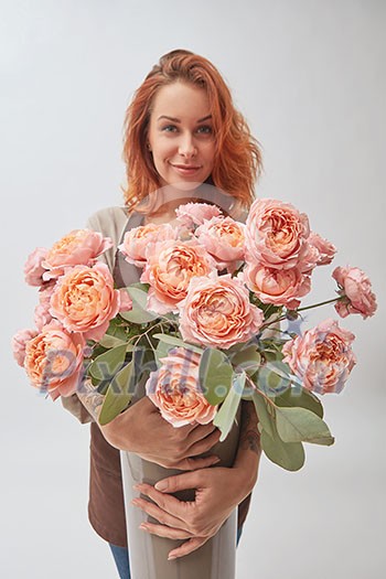 a woman holding a vase in her hands. vase with a bouquet of pink roses, mothers Day, flowers shop concept