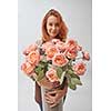 a woman holding a vase in her hands. vase with a bouquet of pink roses, mothers Day, flowers shop concept