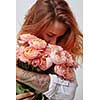 pretty red-haired girl with a tattoo on her arm holding and smell a bouquet of pink roses, valentine's day, mother's day