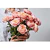 woman holding big fragrant bouquet of pink roses in the hands as a gift. Valentine's Day, Mother's Day