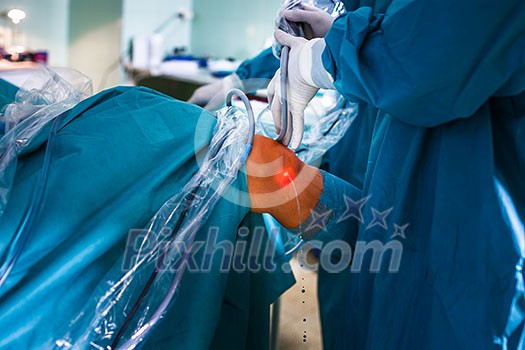 Knee surgery, Orthopedic Operation - two surgeons performing a knee surgery on a patient (shallow DOF; color toned image) Knee surgery, Orthopedic Operation - two surgeons performing a knee surgery on a patient (shallow DOF; color toned image)