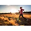 Young woman running outdoors on a lovely sunny winter/fall day (motion blurred image)