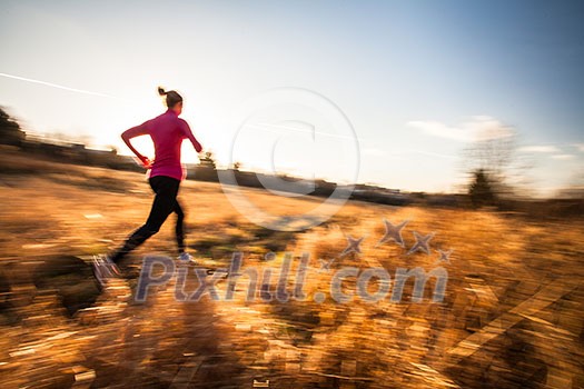 Young woman running outdoors on a lovely sunny winter/fall day (motion blurred image) Young woman running outdoors on a lovely sunny winter/fall day (motion blurred image)