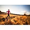 Young woman running outdoors on a lovely sunny winter/fall day (motion blurred image)