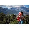 Pretty, female hiker in high mountains packing her backpack