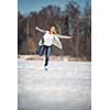 Young woman ice skating outdoors on a pond on a freezing winter day (color toned image; motion blurred image)