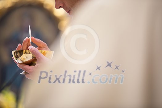 Priest' hands during a wedding ceremony/nuptial mass (shallow DOF; color toned image)