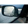 Rear view mirror of a modern car on a winter day(shallow DOF; color toned image)