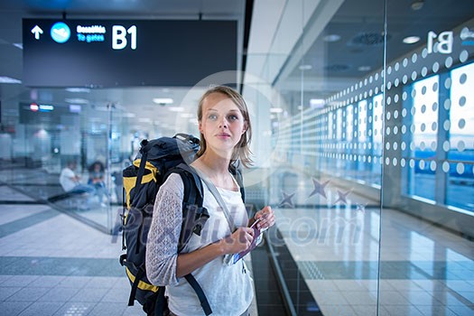 Young female passenger at the airport, waiting for her delayed flight