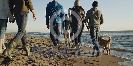 Group Of Young Friends Spending The Day On A Beach during autumn day Group Of Young Friends Spending The Day On A Beach during autumn day