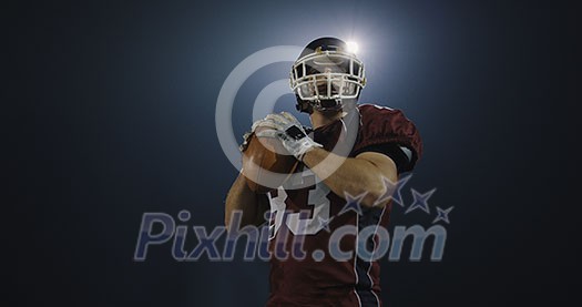 american football player throwing rugby ball against black background