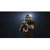 american football player throwing rugby ball against black background