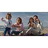 Family with kids resting and having fun at beach during autumn day