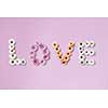 The word love made from different gerbera flowers on a pink background. As layout for post card on Valentine's Day or Mother's Day with . Flat lay.