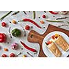 A tasty vegetable burrito on a plate on a wooden board, on a gray concrete background. Step-by-step recipe for cooking. Top view, flat lay.