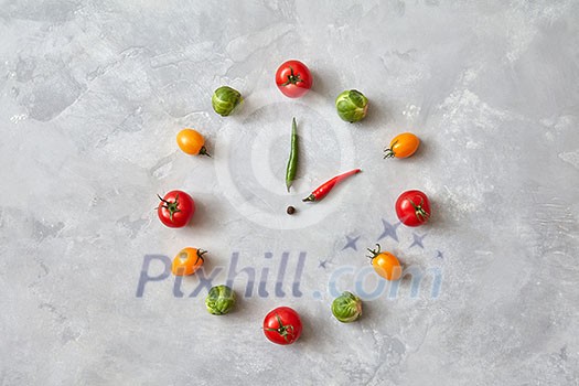 Watches made from tomatoes and Brussels sprouts. The concept of healthy eating. Dinner time. Top view, flat lay. Watches made from tomatoes and Brussels sprouts. The concept of healthy eating. Dinner time. Top view, flat lay.