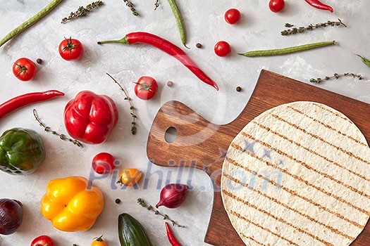 Fresh vegetables and tortilla on a wooden board, the stage of cooking burrito. Step-by-step recipe. Top view, flat lay. Fresh vegetables and tortilla on a wooden board, the stage of cooking burrito. Step-by-step recipe. Top view, flat lay.