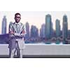 Portrait of young black businessman standing on balcony in front of the big city