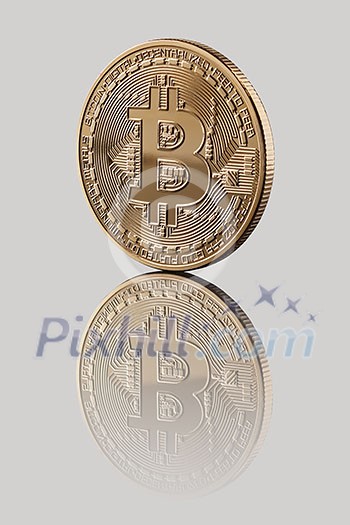 Gold Bitcoin. Reflection of a coin on a gray glossy background. Cryptocurrency