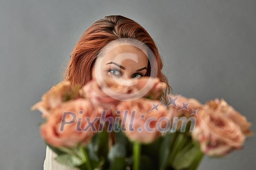 Close-up of a bouquet of beige roses cappuccino.The girl is looking at a bouquet. St. Valentine's Day