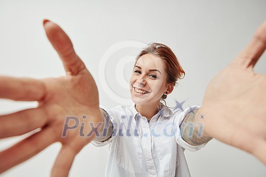 Portrait of a happy young girl with outstretched open hands to embrace. Joyful greeting