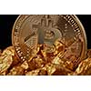 Closeup of gold nugget and Gold Bitcoin Coin on black background . Bitcoin as desirable as digital gold concept. Bitcoin cryptocurrency.