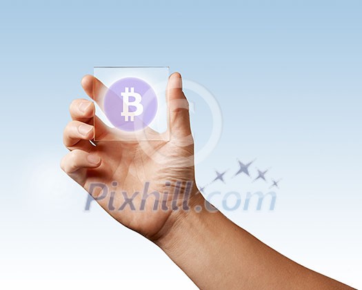 Transparent digital screen is held by a male hand with a bitcoin icon on a blue background. Business, technology and cryptocurrency concept