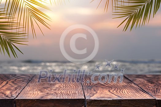 Top of wood table on blurred sea on the sunset with coconut tree background . Empty ready for your product display montage. Concept of beach in summer.