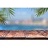 wooden table or wooden mock up with palm trees against the background of a blurry city . Natural background with copy space. Can be used for display products.