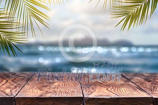 Landscape view with old wood table top and coconut leaf over blurred blue sea and white sand beach with clear blue sky background . Concept Summer Relax and Party. Landscape view with old wood table top and coconut leaf over blurred blue sea and white sand beach with clear blue sky background . Concept Summer Relax and Party.