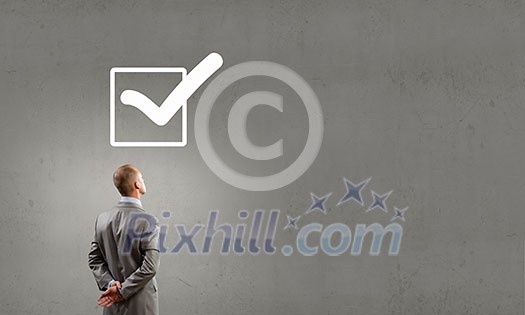 Rear view of businessman looking at tick above head Rear view of businessman looking at tick above head