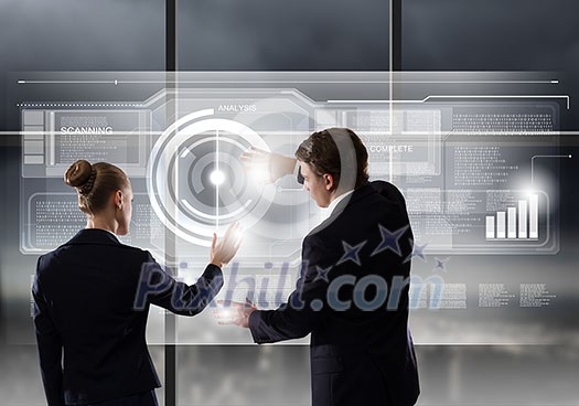 Rear view of businessman and businesswoman touching icon of digital screen Rear view of businessman and businesswoman touching icon of digital screen
