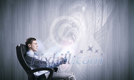 Young businessman with tablet in hands against digital background Young businessman with tablet in hands against digital background
