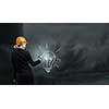 Rear view of woman in hardhat drawing light bulb