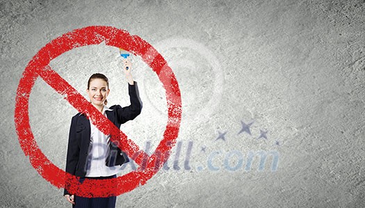 Young businesswoman drawing red prohibition sign with brush Young businesswoman drawing red prohibition sign with brush