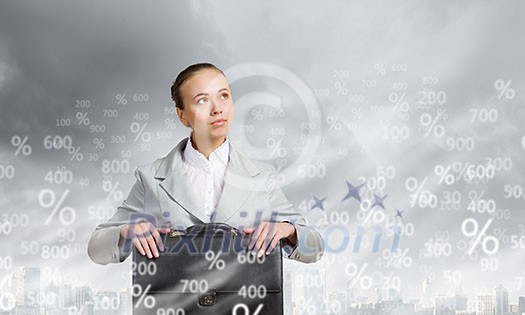 Young pretty businesswoman sitting with briefcase in hands Young pretty businesswoman sitting with briefcase in hands
