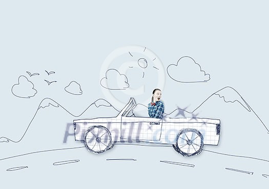 Young girl driving car made of paper Young girl driving car made of paper