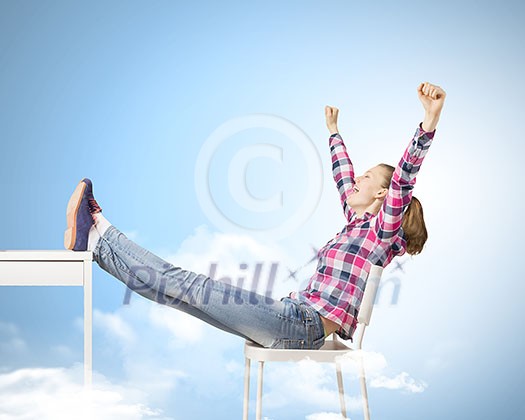 Young woman in casual with arms up celebrating success