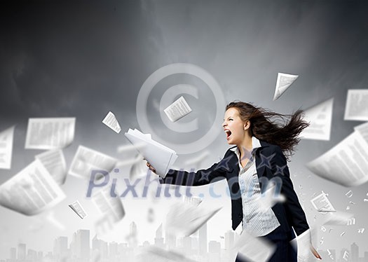 Young determined businesswoman walking against strong wind Young determined businesswoman walking against strong wind
